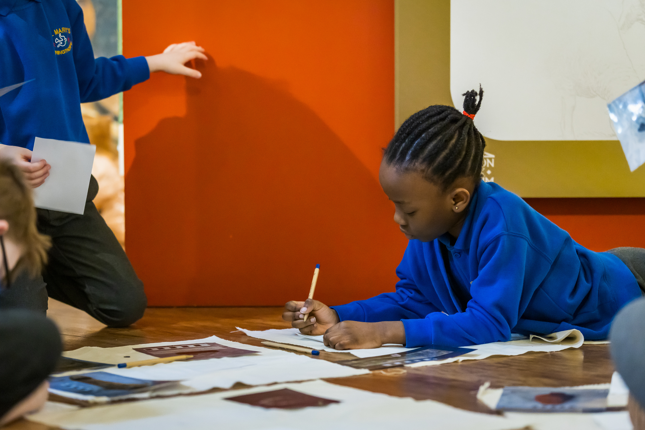 Child writing on a desk in a school.