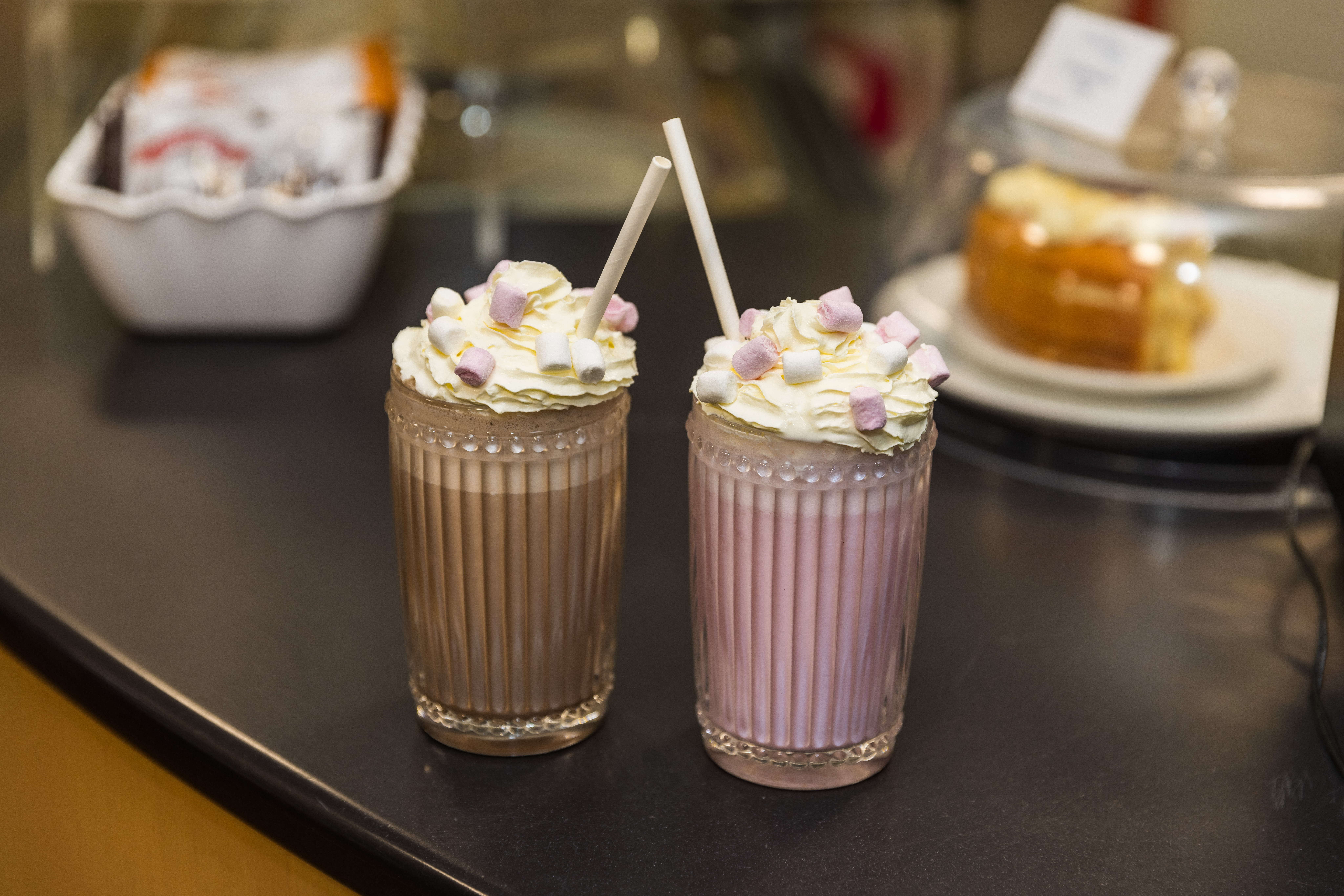 Photo of chocolate and strawberry milkshakes with cream and marshmallows